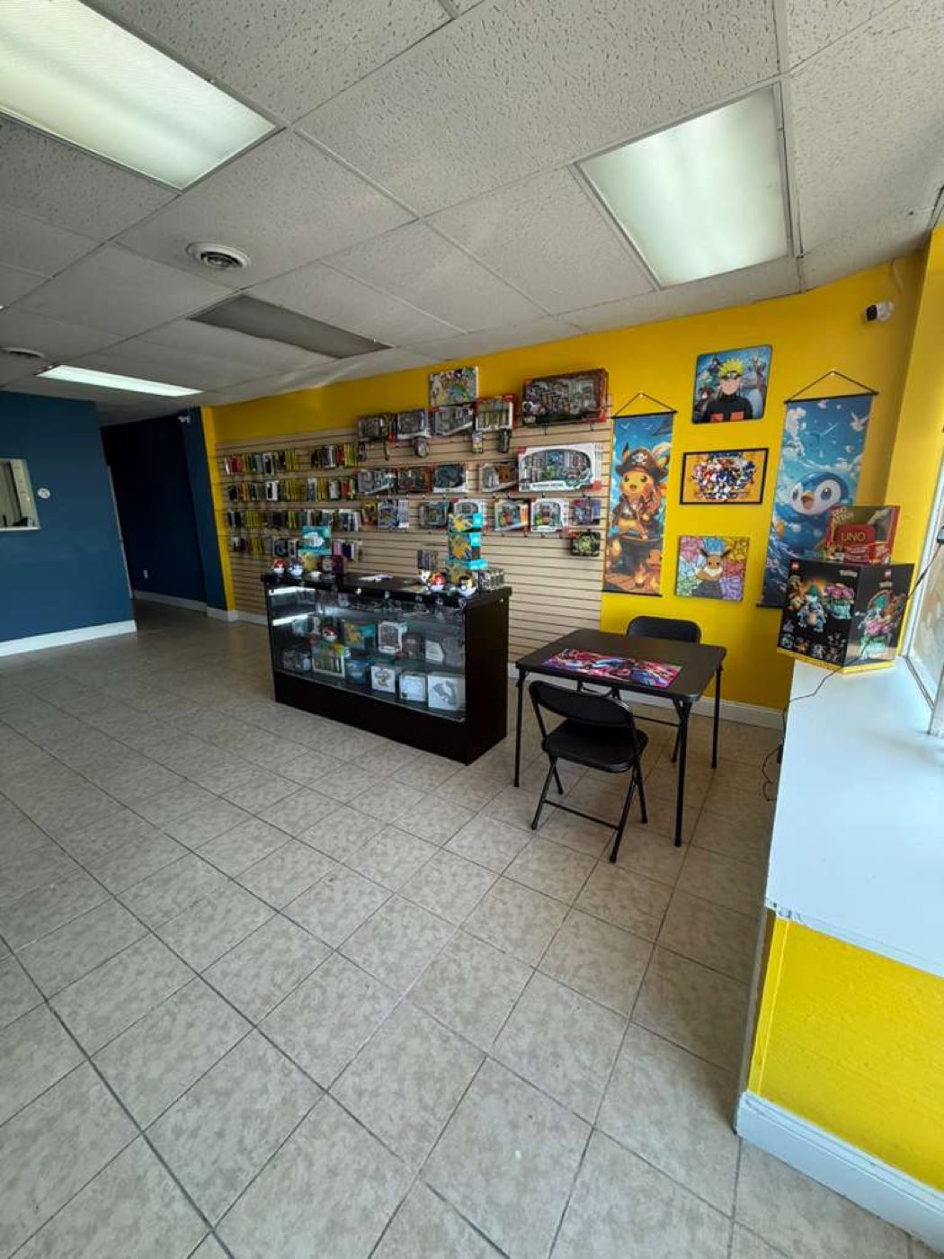 Display case of Pokémon singles and sealed product with play table for trading